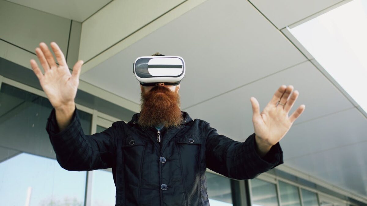 Bearded man wearing VR headset interacts outside modern building. Experiencing virtual reality.